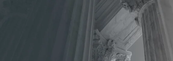 Close-up view of classical marble columns and ornate architectural details, emphasizing grandeur and stability.